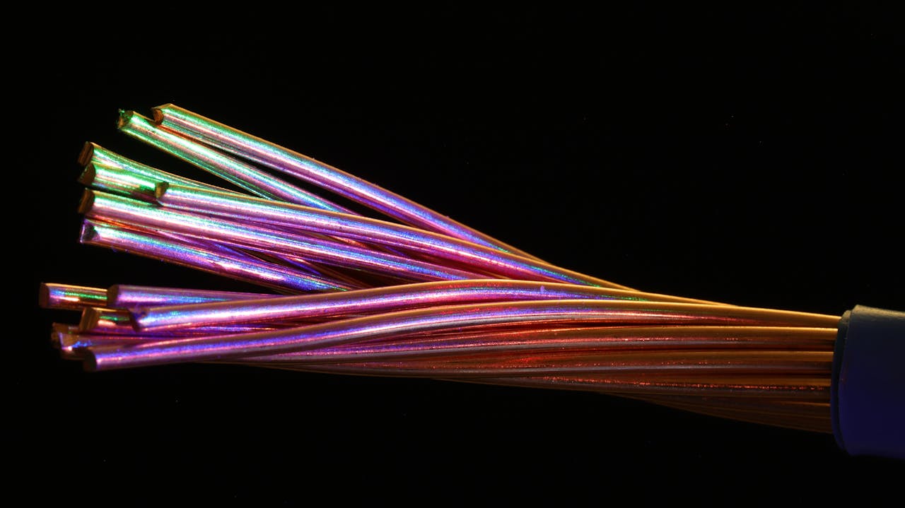 Vibrant multicolor fiber optic cables against a dark setting, showcasing technology and design.
